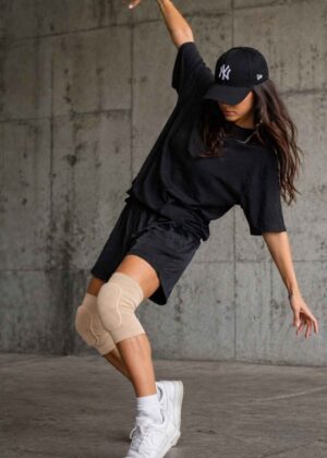 danseres draagt huidskleurige kniebeschermers in streetdance-stijl